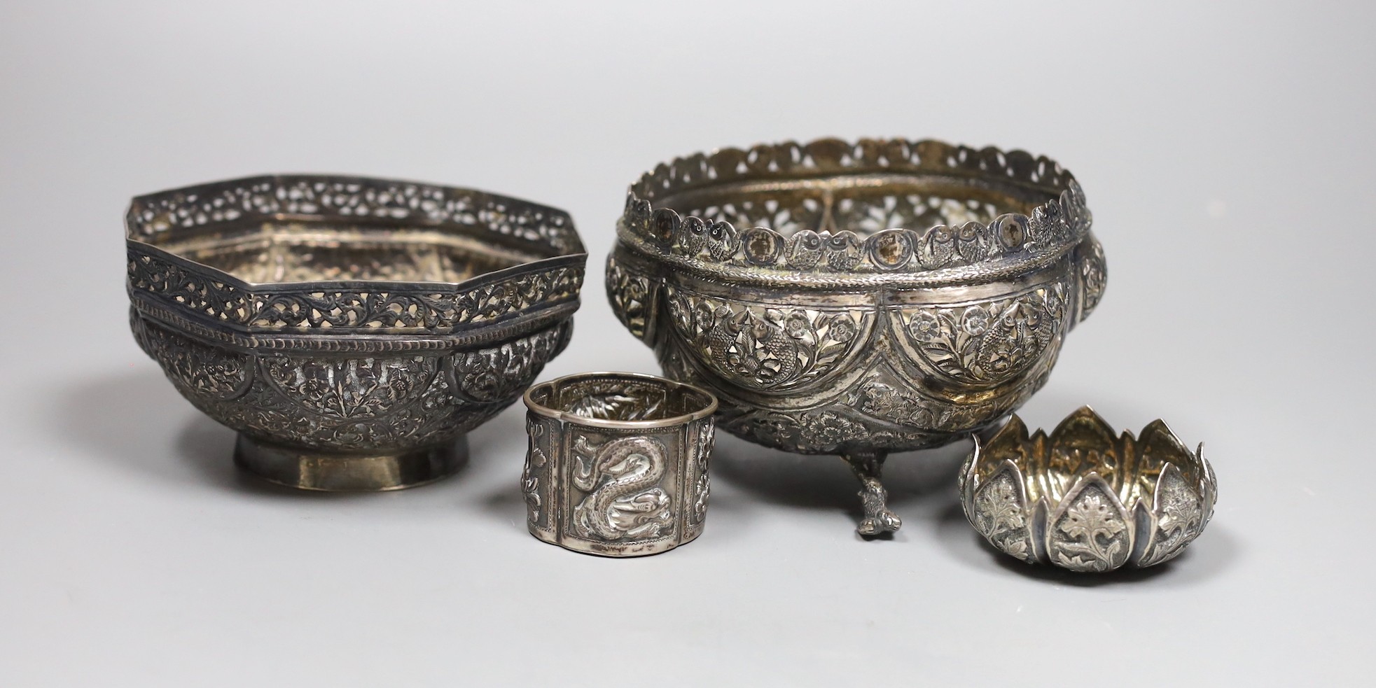 Two early 20th century Indian repousse white metal bowls, widest 12cm, a similar small dish and a salt.